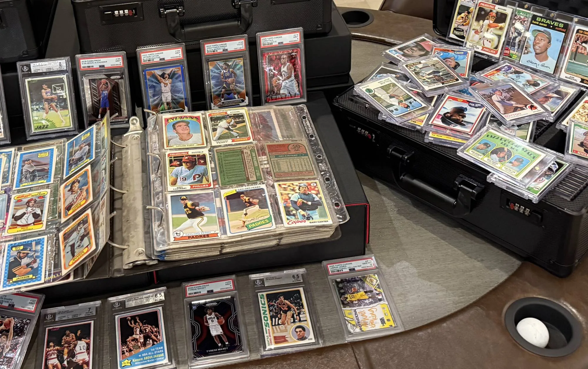 One binder page up close: Gaylord Perry, Greg Luzinski, Jim Palmer and Gary Carter in their pockets, graded cards standing behind, and a case of top-loaded vintage cards beside it.